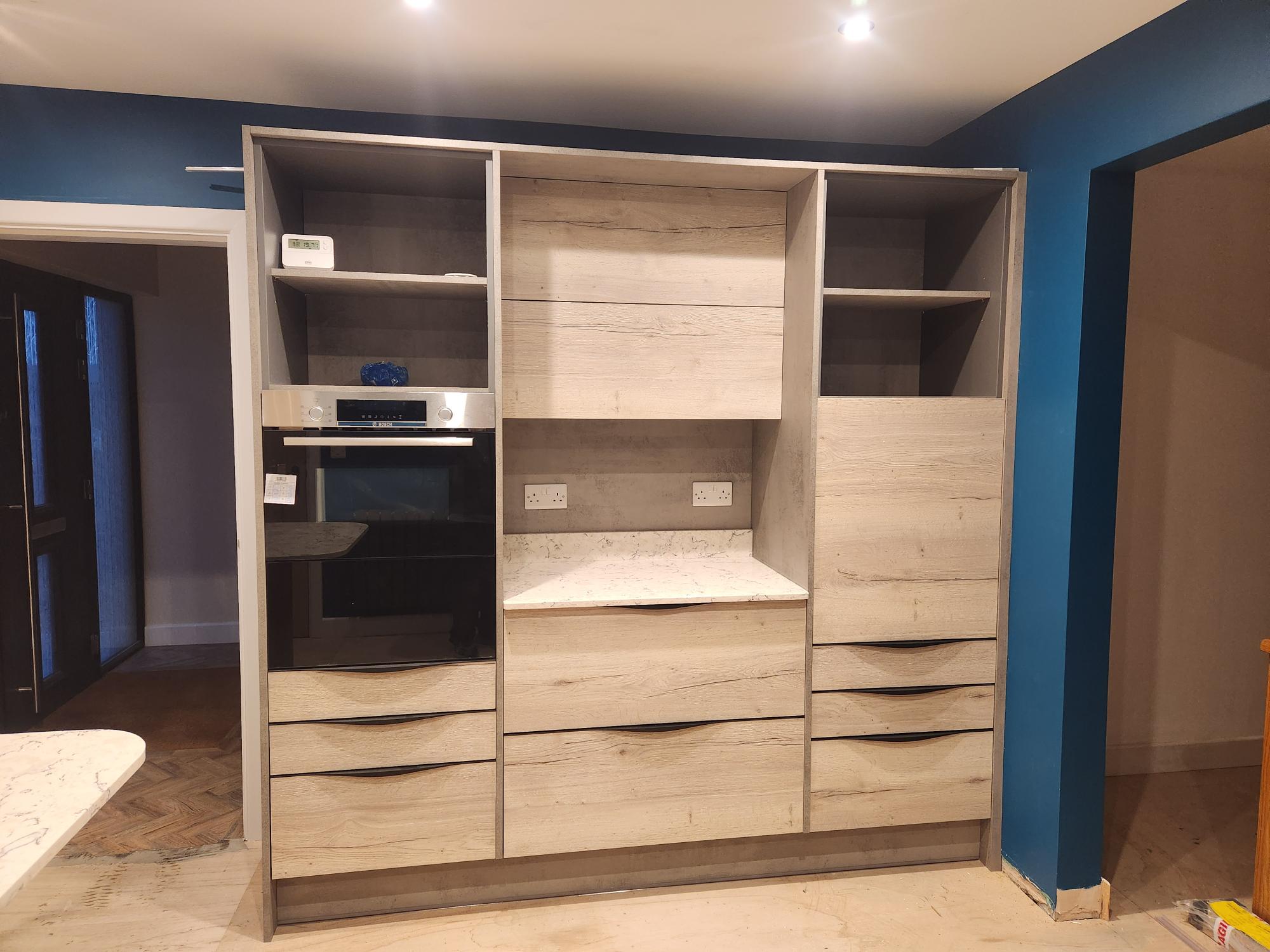 Wood-effect larder unit with integrated oven and storage