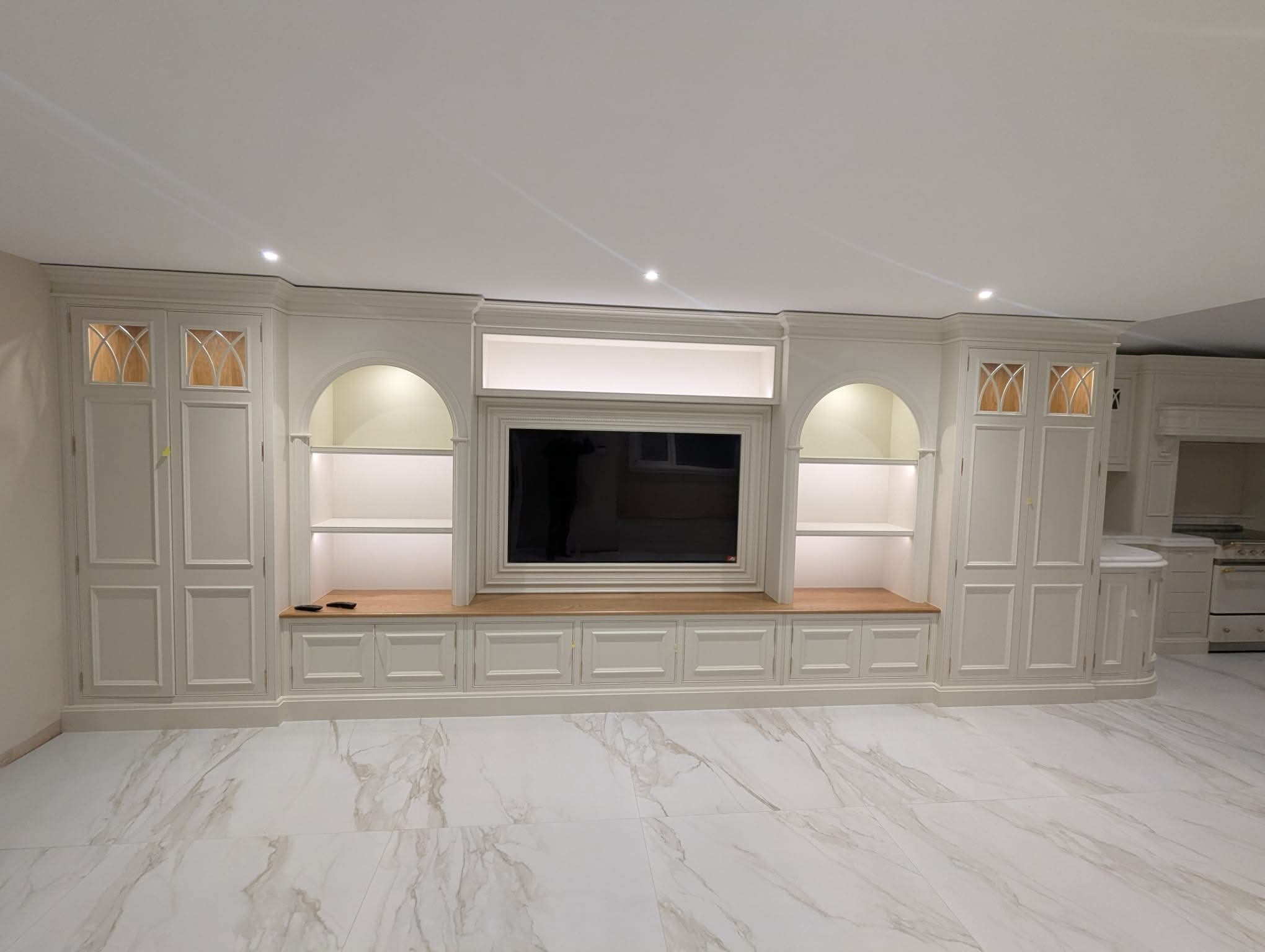 Bespoke media unit with TV recess, lit arched alcoves and gothic glass doors