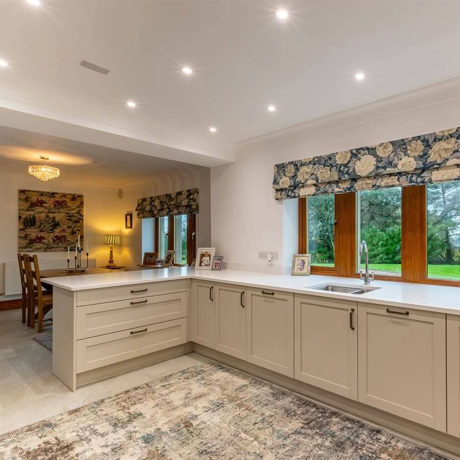 Open plan kitchen with peninsula breakfast bar and garden views